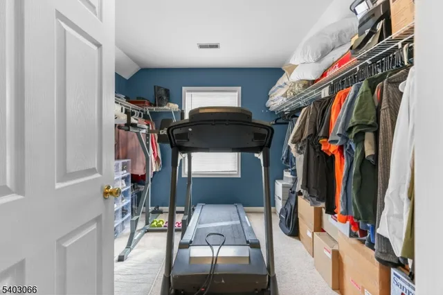 a view of walk in closet with clothes and shoes