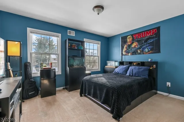 a bedroom with a bed and a dresser next to a window