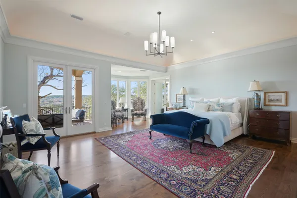 a spacious bedroom with furniture and a chandelier