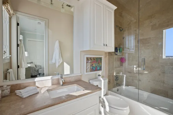 a bathroom with a granite countertop sink and toilet