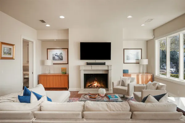 a living room with furniture a flat screen tv and a fireplace
