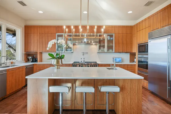 a kitchen with granite countertop a table chairs stove and refrigerator