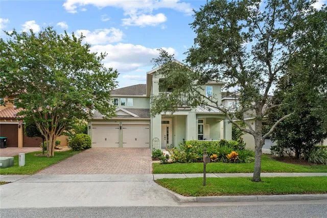 a front view of a house with a garden and trees