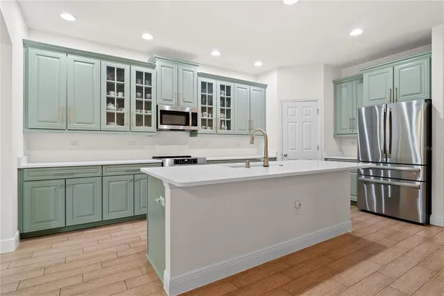 a kitchen with stainless steel appliances granite countertop a sink and refrigerator