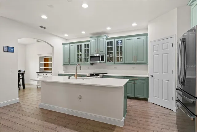 a kitchen with stainless steel appliances granite countertop a sink stove and refrigerator