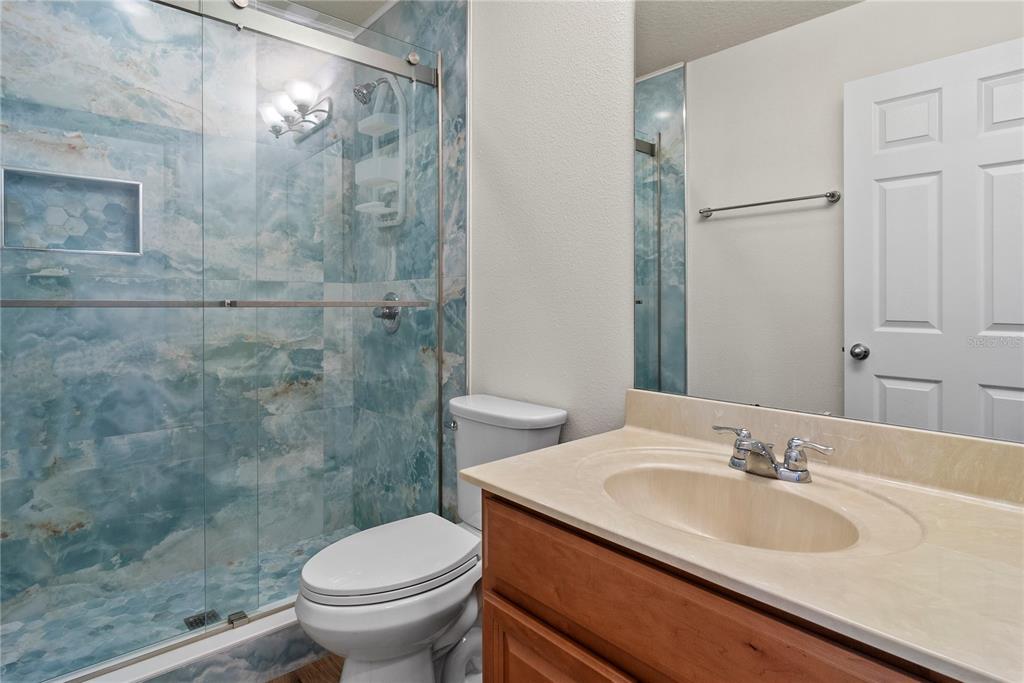 11922 Angle Pond Avenue Windermere, FL 34786 - Photo 26 of 45 a bathroom with a granite countertop sink a toilet and a shower