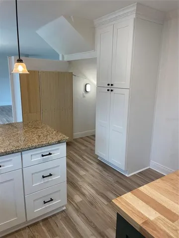 a view of a storage and utility room with wooden floor