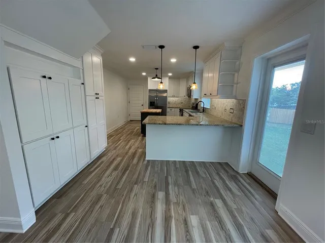 a view of kitchen and hall with wooden floor