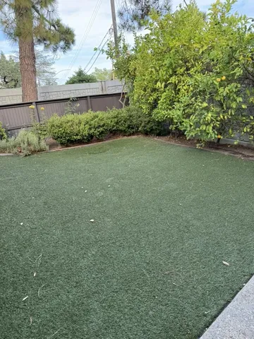 a view of backyard with furniture and a fireplace