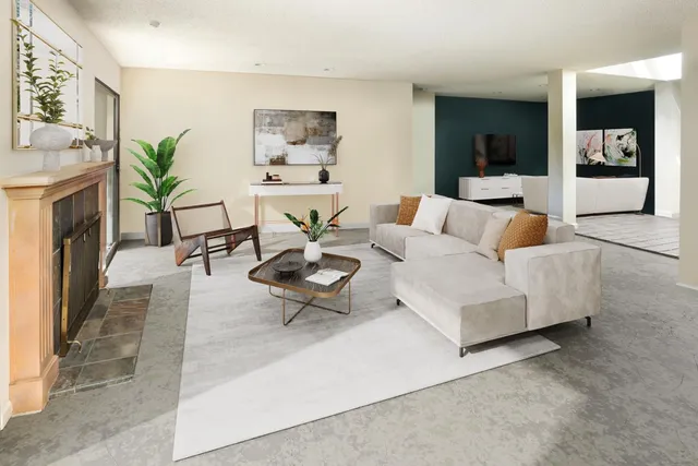 a living room with furniture a fireplace and a potted plant