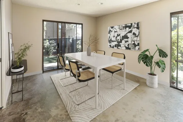 a living room with furniture a potted plant and a large window