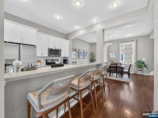 a kitchen with a table chairs microwave and cabinets