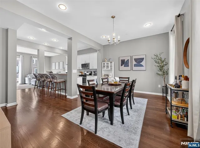 a view of a dining room and livingroom with furniture wooden floor a chandelier