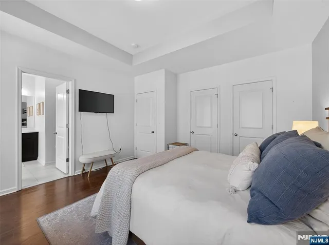 a bedroom with a bed and a refrigerator