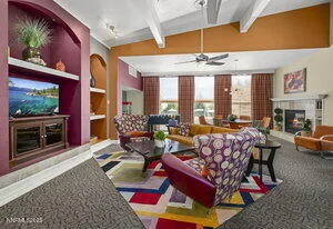 a living room with furniture a chandelier and a floor to ceiling window