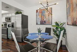 a view of a dining room with furniture a potted plant and wooden floor
