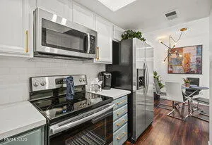 a kitchen with stainless steel appliances a stove a microwave a sink and cabinets