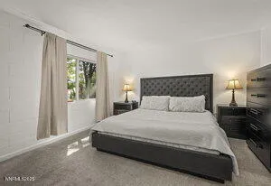 a large bed sitting in a bedroom next to a window