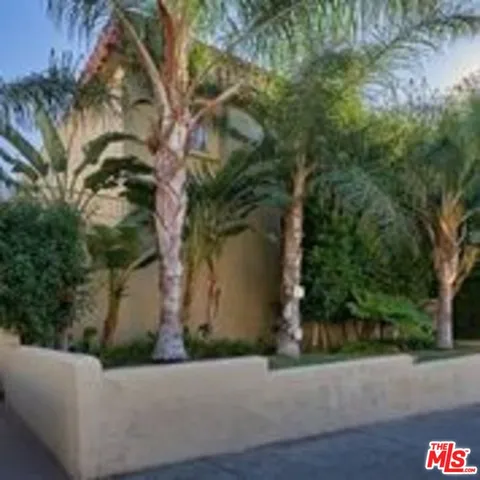 a view of a house with a yard and potted plants