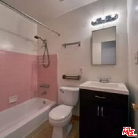 a bathroom with a sink toilet double vanity and bathtub