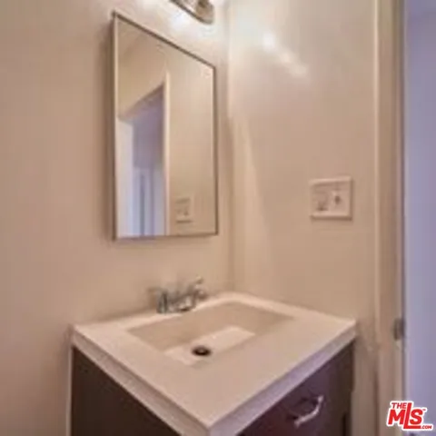 a bathroom with a sink vanity and a mirror