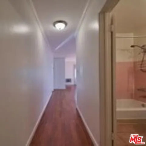 a view of a hallway with wooden floor