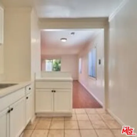 a view of a hallway with wooden floor and cabinet