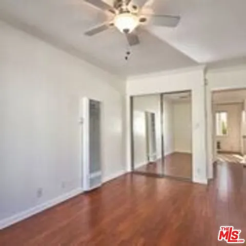 a view of a livingroom with a ceiling fan window and hardwood floor
