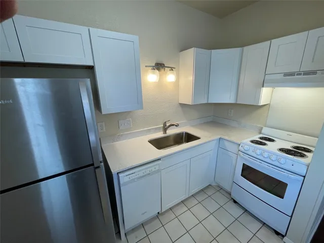 a kitchen with stainless steel appliances a refrigerator sink and cabinets