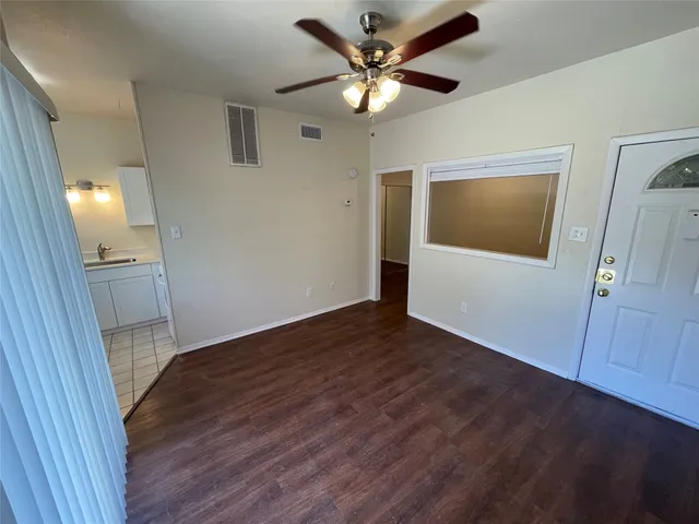 a view of an empty room with wooden floor