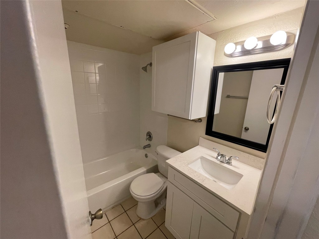 6809 West Gate Boulevard, Unit 110 Austin, TX 78745 - Photo 6 of 7 a bathroom with a sink a toilet and mirror