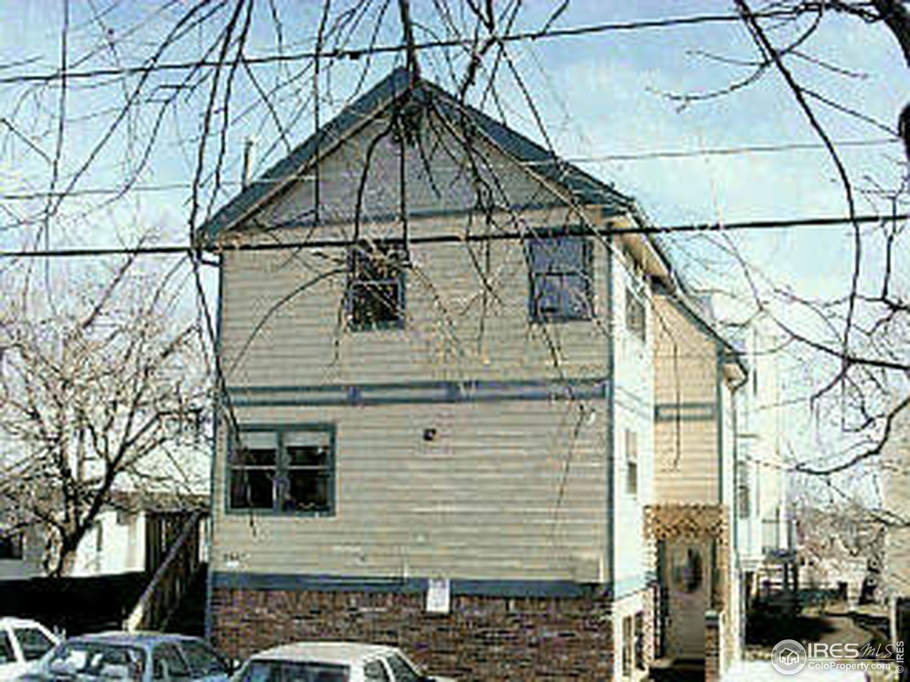 a front view of a house with large trees