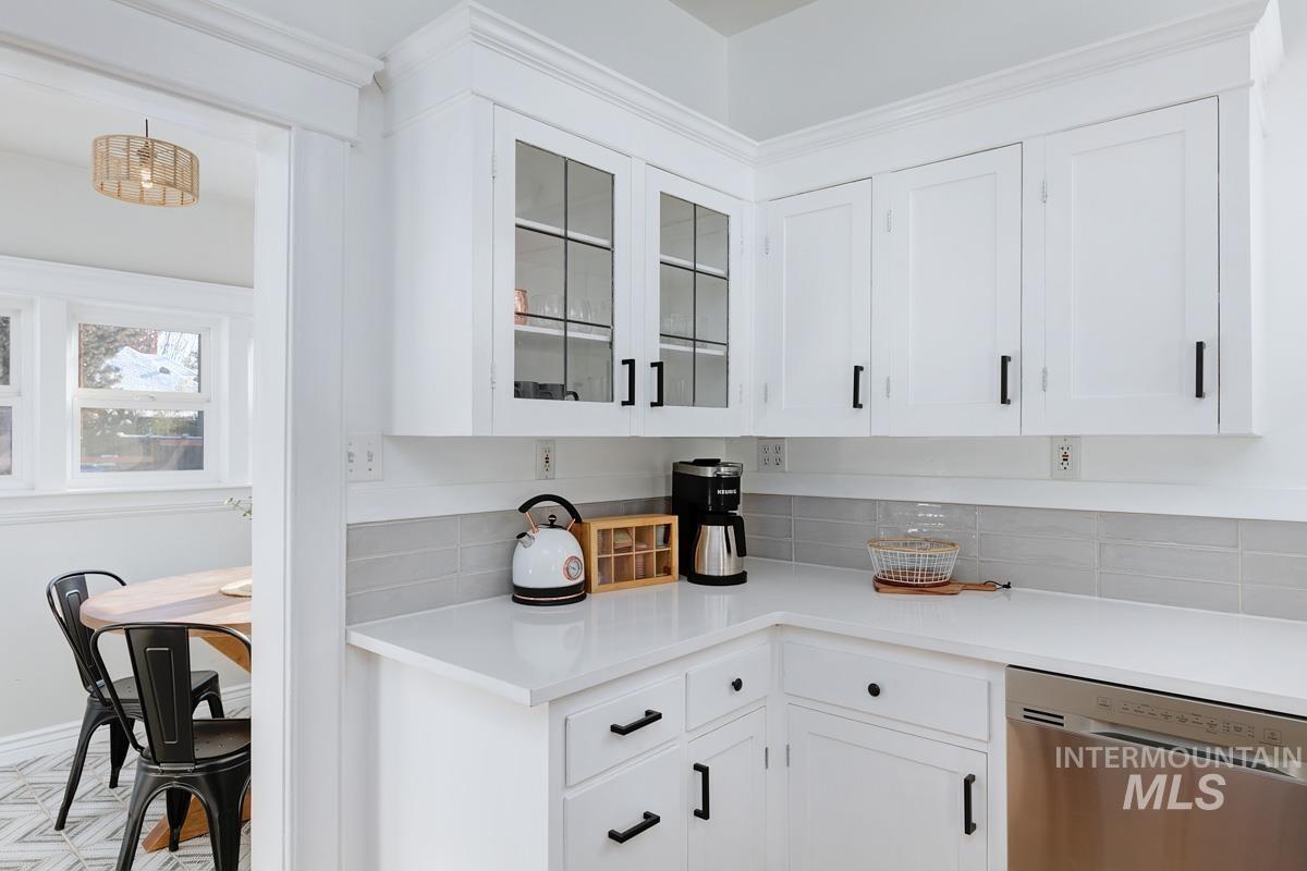 1904 North 16th Street Boise, ID 83702 - Photo 16 of 28 Kitchen featuring white cabinetry, dishwasher, glass fronted cabinets, and backsplash