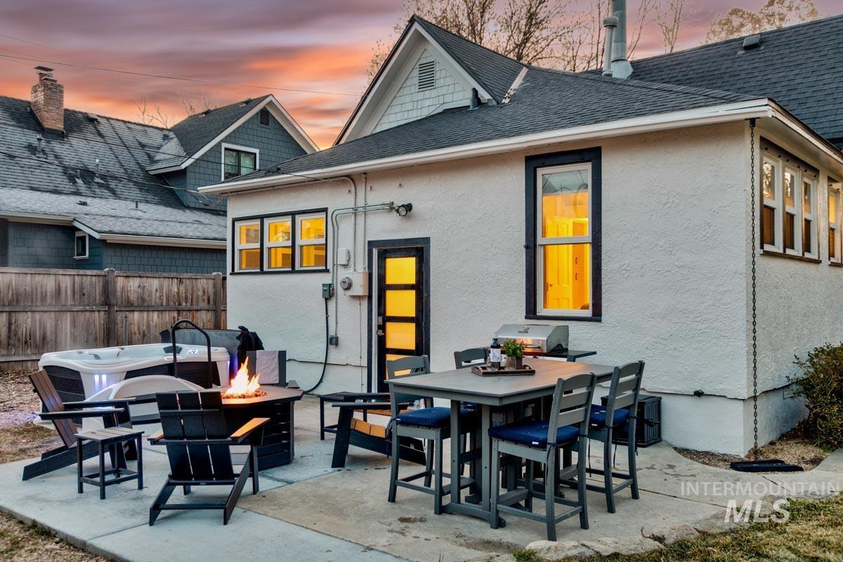 1904 North 16th Street Boise, ID 83702 - Photo 4 of 28 Rear view of property with a shingled roof, a patio area, a fire pit, outdoor dining space, and stucco siding