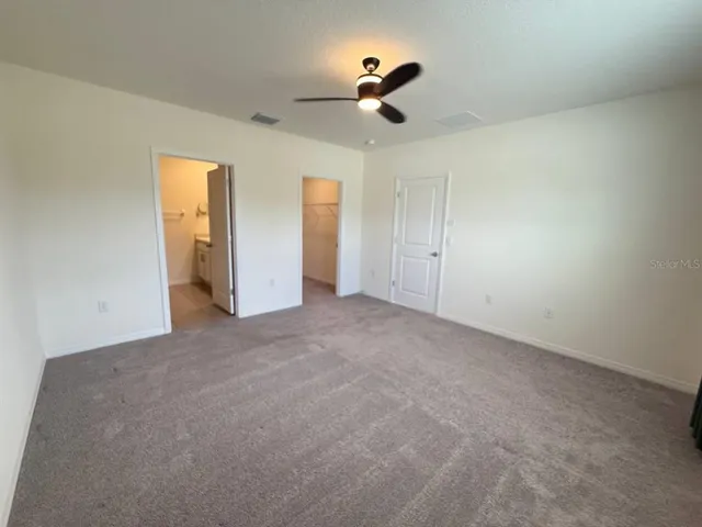 a view of an empty room with a ceiling fan