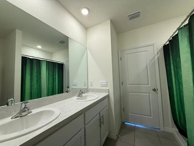 a bathroom with a double vanity sink and a mirror
