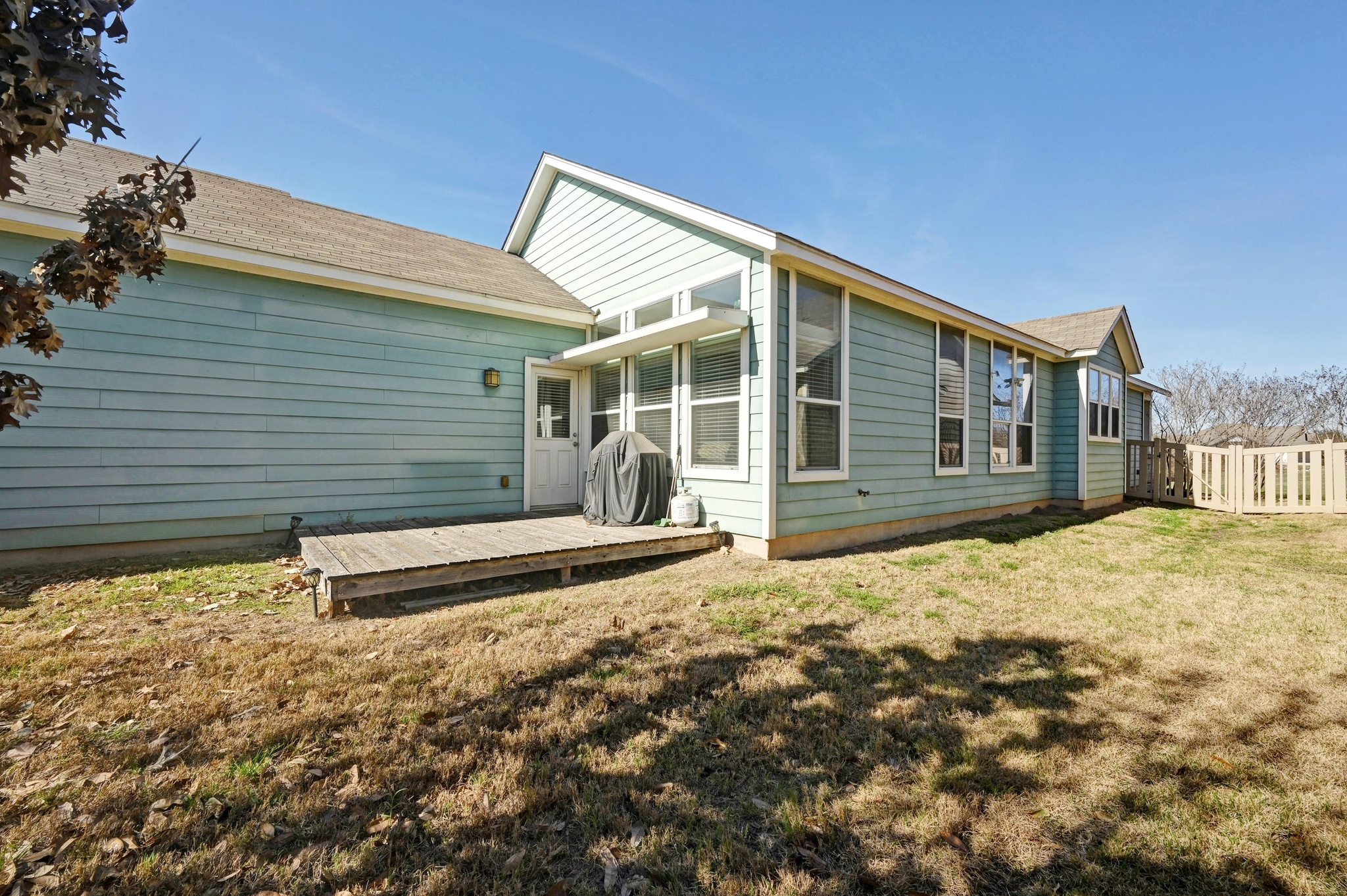 1480 Sanders Kyle, TX 78640 - Photo 5 of 27 A rear alley leads to an attached two-car garage, while a fenced side and backyard connect to a private deck.