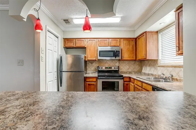 a kitchen with stainless steel appliances granite countertop a refrigerator and a sink