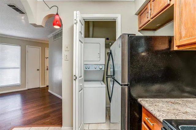 a kitchen view with granite countertop a refrigerator and a sink