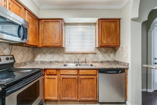 a kitchen with granite countertop cabinets stainless steel appliances and a sink