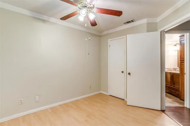 a view of an empty room and chandelier fan