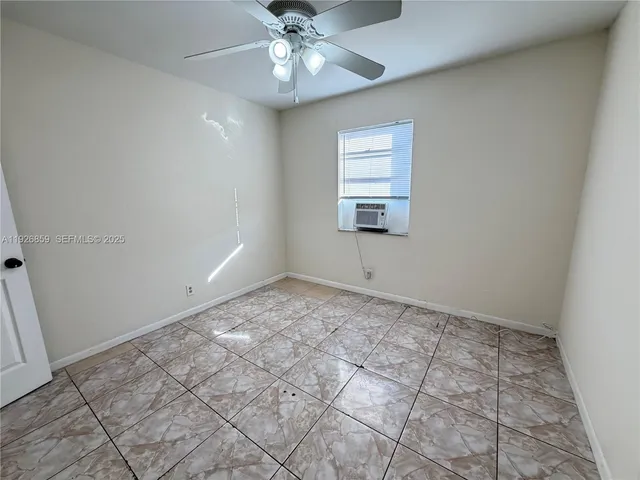an empty room with a ceiling fan and a bathroom