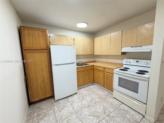 a kitchen with a refrigerator sink stove and cabinets