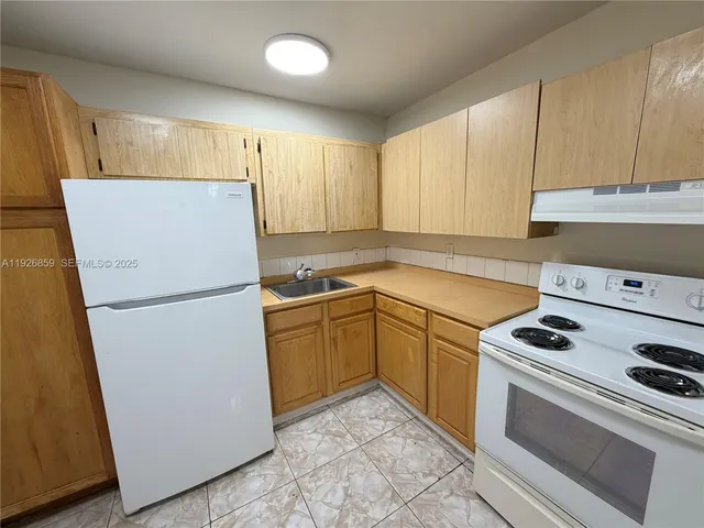 a kitchen with a refrigerator sink stove and cabinets