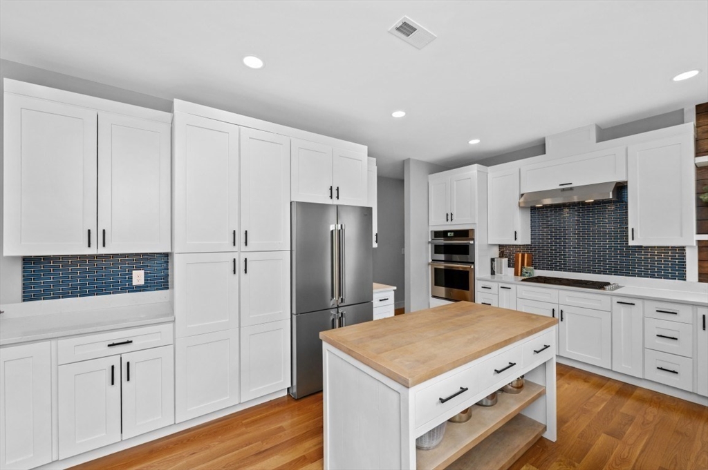 61 Paul Revere Road, Unit 2 Arlington, MA 02476 - Photo 12 of 33 a kitchen with white cabinets and stainless steel appliances