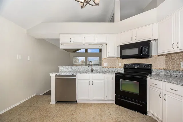 a kitchen with stainless steel appliances granite countertop a stove a sink and a microwave
