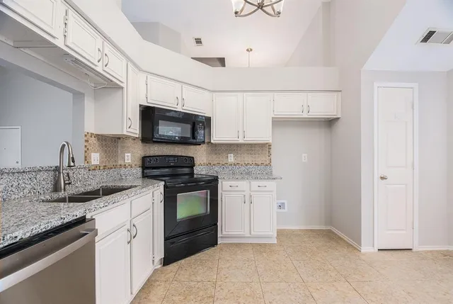 a kitchen with stainless steel appliances granite countertop a sink stove and microwave