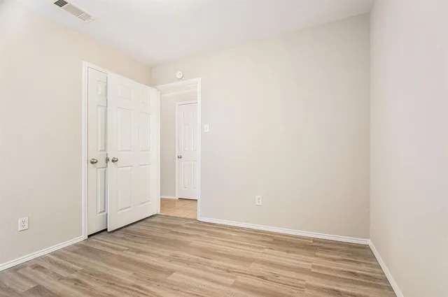 a view of an empty room with wooden floor