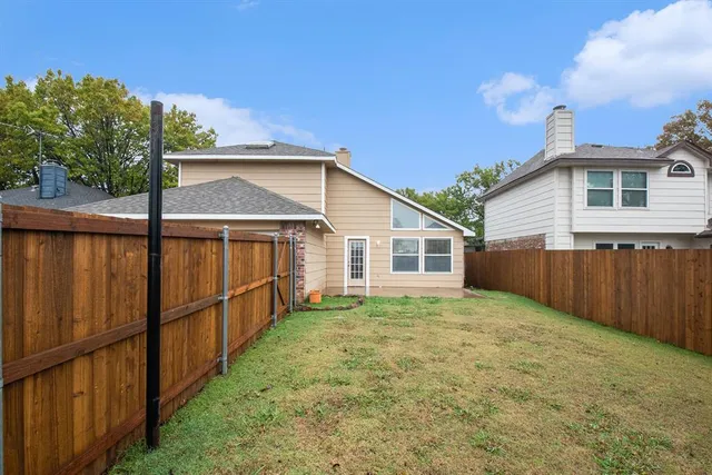 a view of a backyard with wooden fence
