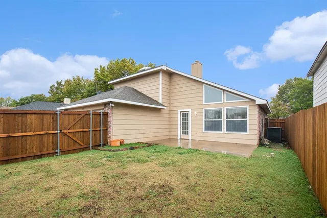 a backyard of a house with plants and wooden fence